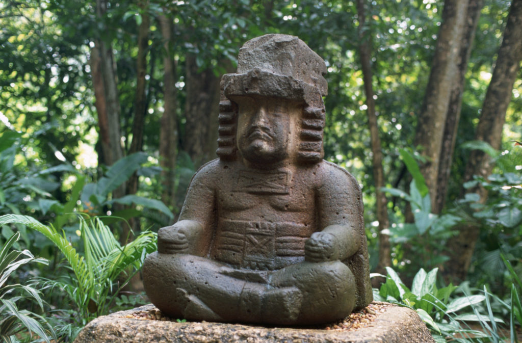 26 Nov 1995, Villahermosa, Tabasco, Mexico --- An Olmec figure known as that wears a cape and elaborate headdress. It was brought from the ruins of La Venta to the Tabascan capital of Villahermosa, in a setting designed for it by the poet Carlos Pellecer. --- Image by © Danny Lehman/CORBIS